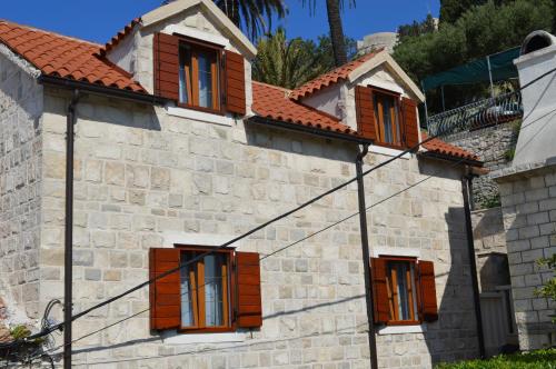 a building with brown shuttered windows on it at Apartments Lea in Hvar