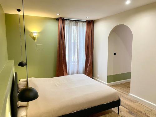 a bedroom with a bed in front of a window at Logement de charme cure proche La Roche-Posay in Saint Etienne