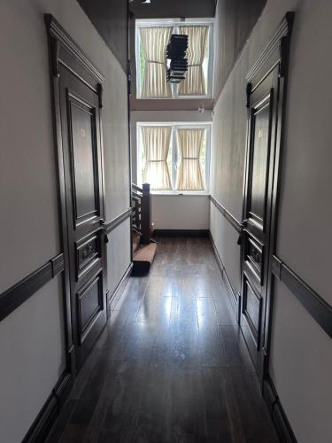 an empty hallway with two windows and a wooden floor at Едем in Brzezhany
