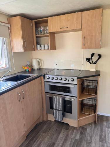 a kitchen with a stove and a sink at Cabana Escape in Little Clacton