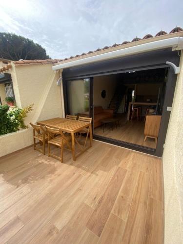 d'une terrasse avec une table en bois. dans l'établissement Villa MADERA HV57 Luxe 4 personnes, au Cap d'Agde
