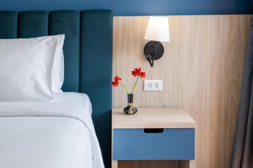 a bedroom with a bed and a table with flowers on it at Phuket Island View Resort - SHA Extra Plus in Karon Beach