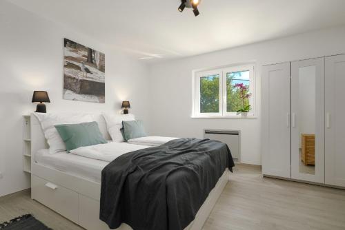 Un dormitorio blanco con una cama grande y una ventana. en Casa Philu in quiet area with amazing view, en Labin