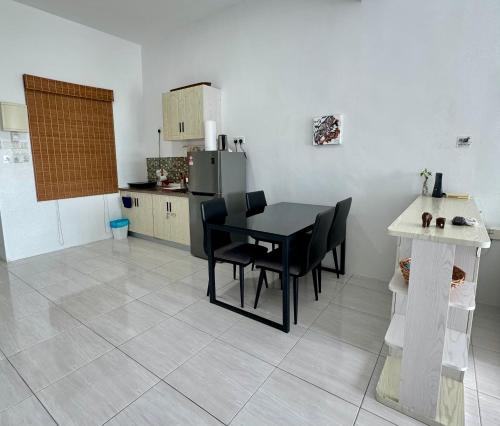 a kitchen with a black table and black chairs at Full Moon Apartment (月满公寓）网红 airbnb in Kuah