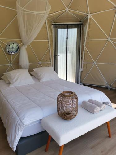 - une chambre avec un grand lit et un panier sur un banc dans l'établissement Le Sicilien Dome et Spa privatif, à Saint-André-de-Roquelongue
