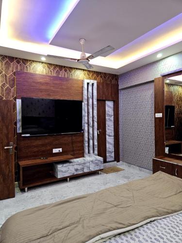 a living room with a large entertainment center with a flat screen tv at Ajay homestay in Jhūsi
