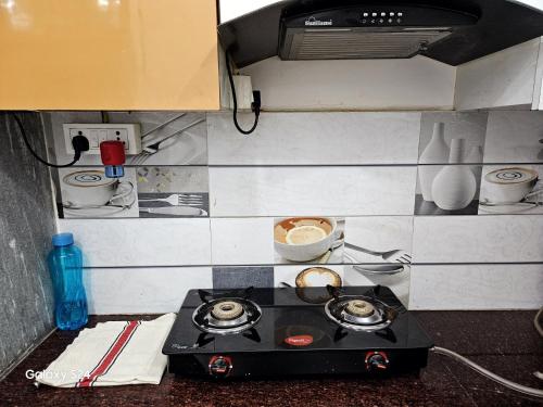 a small kitchen with a stove top in a kitchen at Ajay homestay in Jhūsi