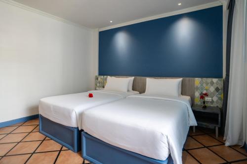 two beds sitting next to each other in a room at Phuket Island View Resort - SHA Extra Plus in Karon Beach