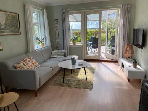 a living room with a couch and a table at Hyggeligt hus på landet mellem Billund og Vejle in Bredsten