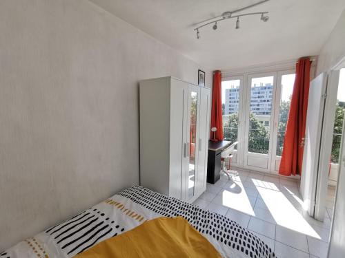 une chambre avec un lit et une fenêtre avec des rideaux rouges dans l'établissement Appartement avec 3 chambres Nantes, Pont du cens, à Orvault
