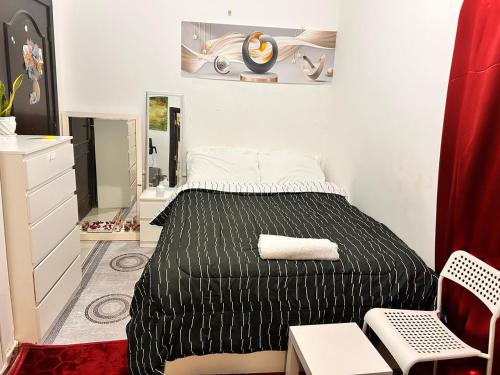 a bedroom with a black bed and a mirror at StanMan guest house 3 in Abu Dhabi Intl