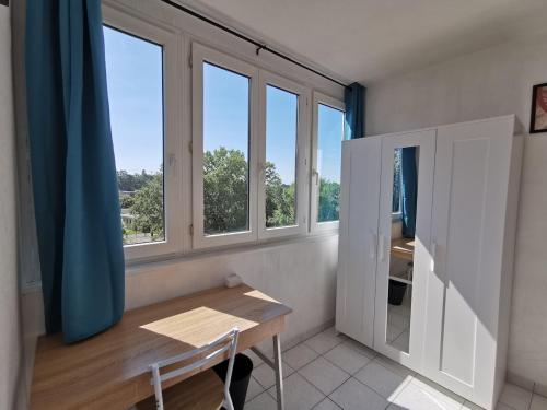 Cette chambre dispose d'une table et de fenêtres. dans l'établissement Appartement avec 3 chambres Nantes, Pont du cens, à Orvault