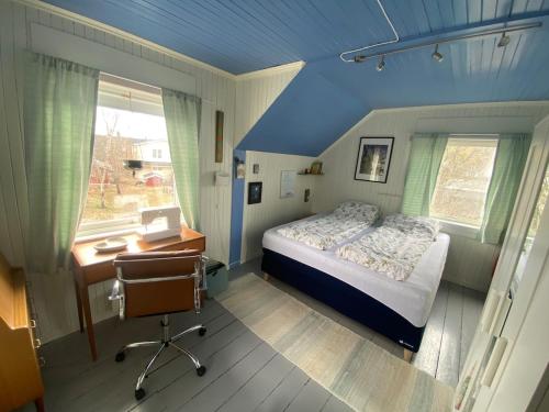 a bedroom with a bed and a desk and a window at Hus i Kabelvåg sentrum in Kabelvåg