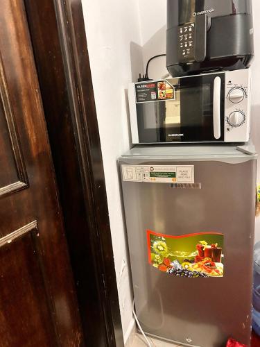 a microwave sitting on top of a refrigerator at StanMan guest house 3 in Abu Dhabi Intl