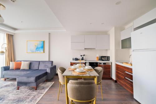 a kitchen and living room with a table and a couch at Modern Furnished Apartments in Istanbul Basaksehir By Iradah Gayrimenkul in Basaksehir