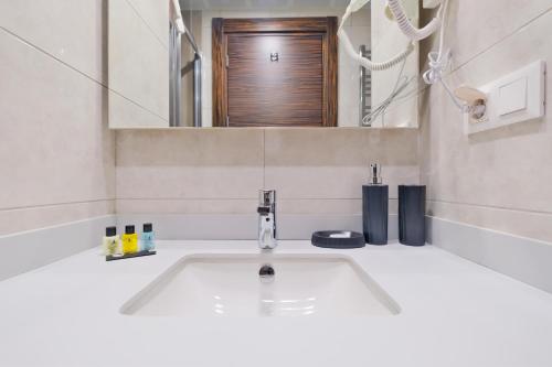a bathroom with a white sink and a mirror at Modern Furnished Apartments in Istanbul Basaksehir By Iradah Gayrimenkul in Basaksehir