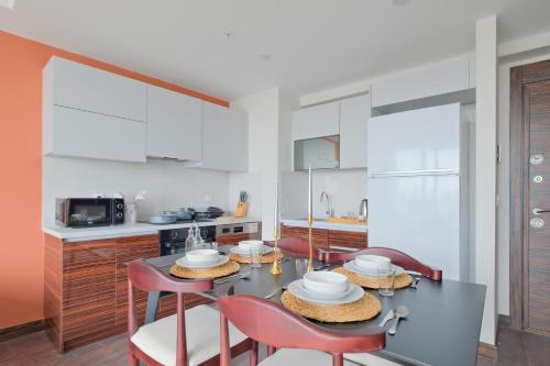 a kitchen with a table and four chairs and a kitchen with white cabinets at Modern Furnished Apartments in Istanbul Basaksehir By Iradah Gayrimenkul in Basaksehir