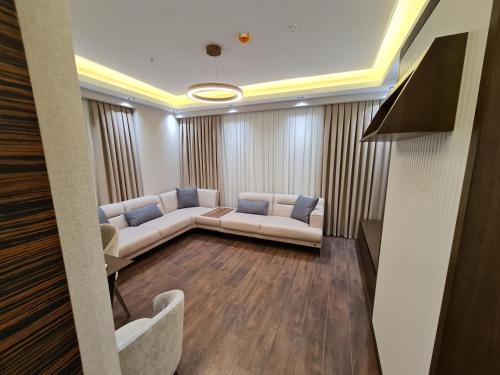 a living room with a white couch and blue pillows at Modern Furnished Apartments in Istanbul Basaksehir By Iradah Gayrimenkul in Basaksehir