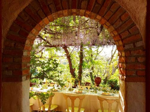 an archway with a table with wine glasses on it at Krasberry Ježev brlog in Komen