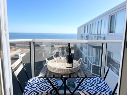 a table with two glasses and a bottle of wine at Beachside retreat with ocean views in Glenelg in Glenelg