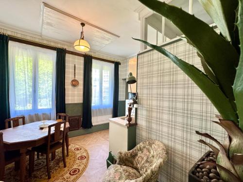 une salle à manger avec une table et une plante dans l'établissement Relais des Anges, à Abbeville