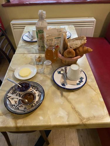 una mesa con platos de comida y pan. en Le Dauphiné, en Châtillon-en-Diois