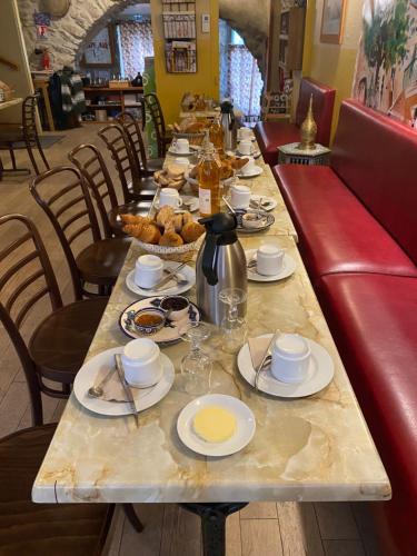 Una mesa larga con platos de comida encima. en Le Dauphiné, en Châtillon-en-Diois