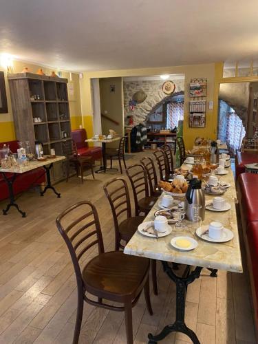 une salle à manger avec une longue table et des chaises dans l'établissement Le Dauphiné, à Châtillon-en-Diois