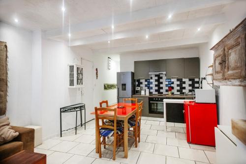 une cuisine avec une table et un réfrigérateur rouge dans l'établissement Proche du port et tout confort, à La Ciotat