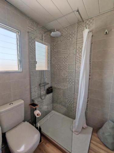 a bathroom with a shower and a white toilet at Costamar bungalow familiar, piscina y terraza, a 5 min de la playa in Arenales del Sol