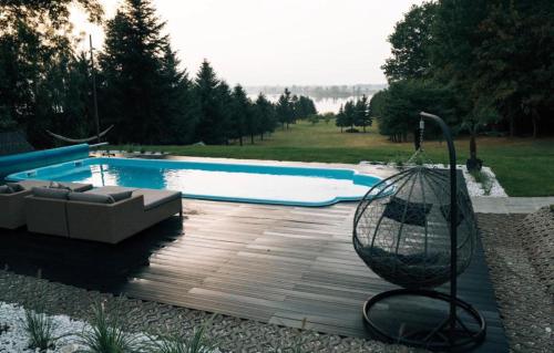 a swimming pool with a bench and a swing at THE VIEW - WILLA z basenem in Iława
