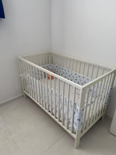 a white crib in a corner of a room at Veralto - Modern Suite with Como Lake view in Vacallo