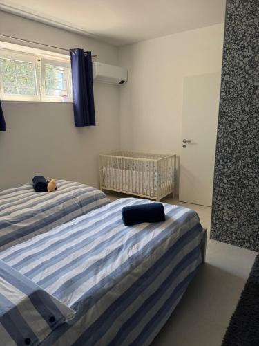 a bedroom with two beds and a baby crib at Veralto - Modern Suite with Como Lake view in Vacallo