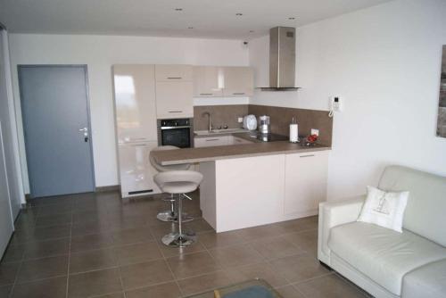 a kitchen with white cabinets and a couch in a room at SOLENZARA sea view in Sari Solenzara