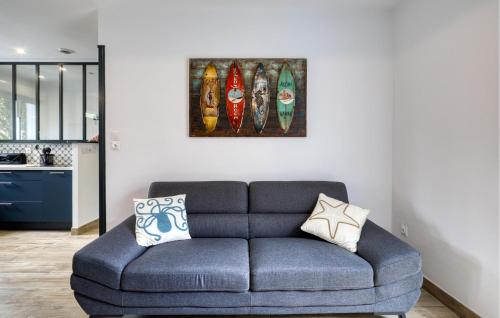 - un canapé bleu dans le salon orné d'une peinture murale dans l'établissement 3 Bedroom Cozy Home In La Tremblade, à La Tremblade