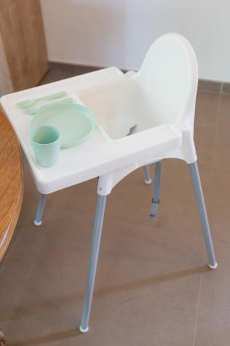 a white high chair with two bowls on it at Les jardins du Quesnoy - 25min de Pairi Daiza in Blicquy