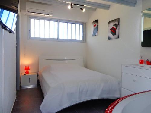 une chambre blanche avec un lit et une fenêtre dans l'établissement Villa LA COQUINE Héliovillage 20 Luxe - 4 personnes, au Cap d'Agde
