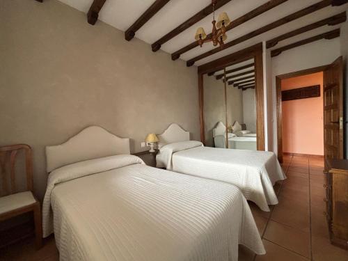 due letti in una stanza con lenzuola bianche di Casa de turismo rural - Mirador de Santa Marina a Sobradillo