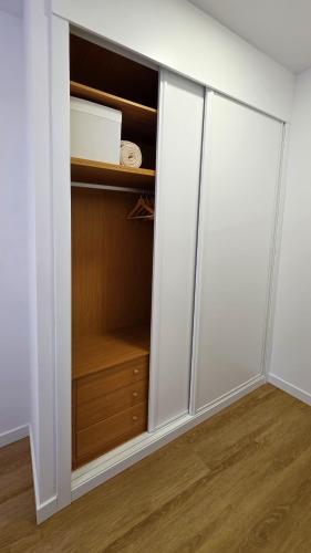 a closet with white walls and wooden cabinets at Rías Baixas Playa Vilariño, Ria de Aldan in Aldán