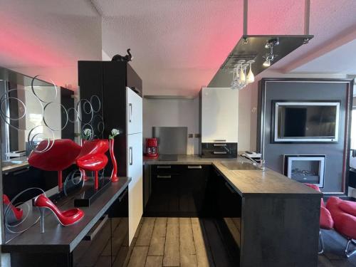 une grande cuisine avec des tabourets rouges et un comptoir dans l'établissement Appartement LES MAMOURS PN 543 - Luxe - 2 personnes, au Cap d'Agde