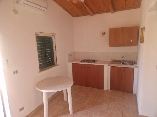 eine kleine Küche mit Tisch und Hocker in der Unterkunft Casa vacanza sul mare 1 in Santa Caterina Dello Ionio Marina