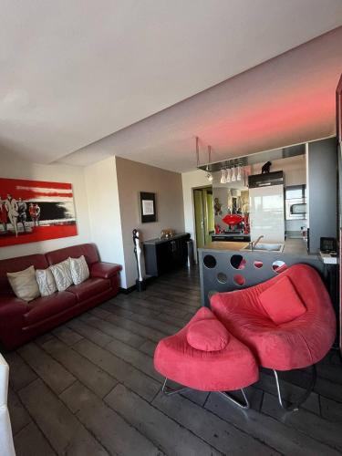 - un salon avec un canapé et deux fauteuils rouges dans l'établissement Appartement LES MAMOURS PN 543 - Luxe - 2 personnes, au Cap d'Agde