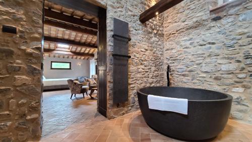 a bathroom with a large tub in a stone wall at La Torre sulla via Francigena in Gambassi Terme