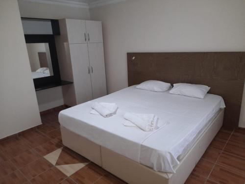 a bedroom with a large white bed with two white towels at Aydın palace termal in İhsaniye