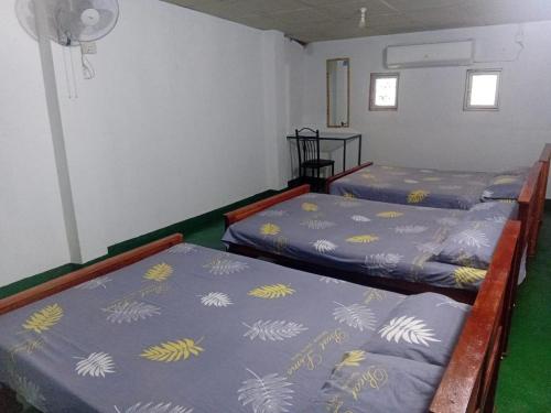 two beds in a room with green at New Samanali Resort in Kataragama