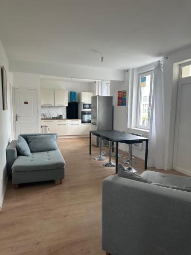 un salon avec une table et un canapé dans l'établissement Sweet mother share studio, à Lille