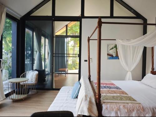ein Schlafzimmer mit Himmelbett und Balkon in der Unterkunft cloud & countyard in Mae Rim