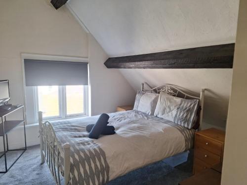 a bedroom with a bed and a window at Aisha’s Attic in Rhyl