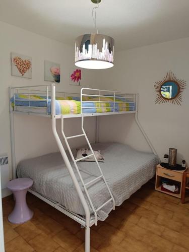 - une chambre avec 2 lits superposés et un lustre dans l'établissement T2 RDC, terrasse au calme, Résidence avec piscine, à Argelès-sur-Mer