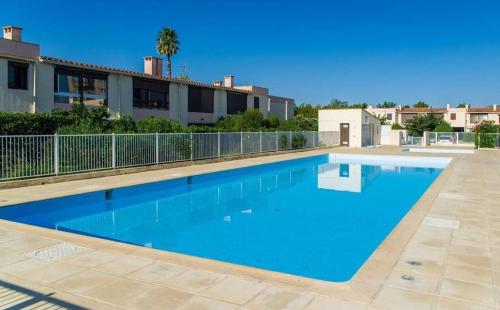 une grande piscine bleue devant un immeuble dans l'établissement T2 RDC, terrasse au calme, Résidence avec piscine, à Argelès-sur-Mer